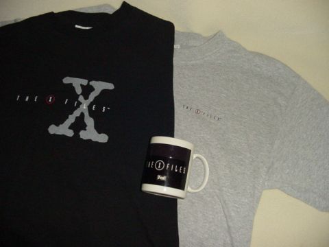 2001 Isuzu Vehicross - A collection of The X-Files merchandise including two t-shirts and a mug is displayed.