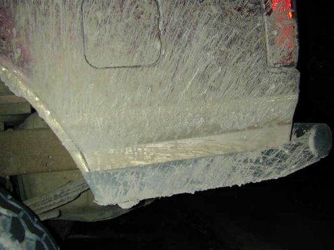 1996 Ford Bronco - The rear of a vehicle is covered in mud, obscuring its details.
