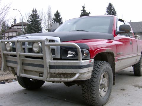 1989 Chevrolet Blazer - This red pickup truck features a large bull bar and aftermarket headlights.