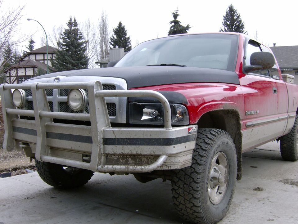 red pickup truck with black hood and bull bar