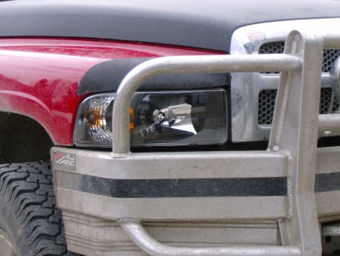 1989 Chevrolet Blazer - A close-up view of a red truck's front end, showing the headlight and part of the grille.