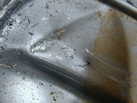 1996 Ford Bronco - This close-up shows the underside of a vehicle, covered in dirt and debris, with some staining from fluids.