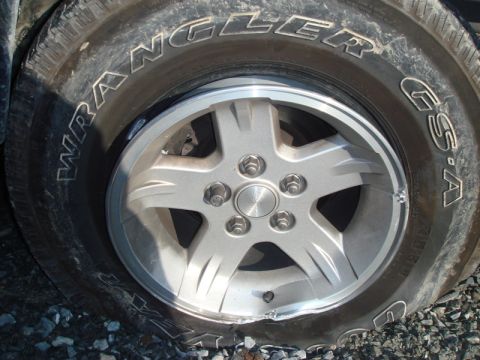1996 Ford Bronco - A flat tire with a damaged rim is visible on a vehicle.