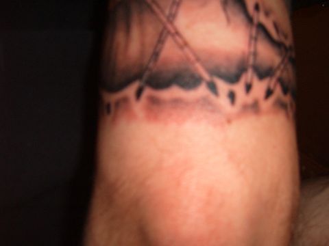 1993 Ford Bronco - The tattoo appears to be a band with a jagged edge, possibly depicting a landscape or abstract pattern.