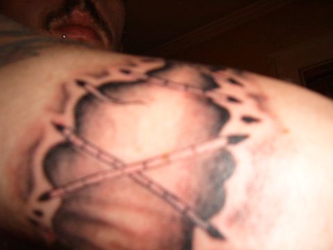 1993 Ford Bronco - A tattoo depicts crossed drumsticks superimposed over a cloud design on a person's arm.