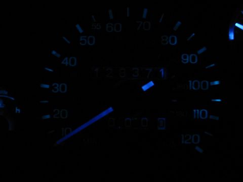 1995 Ford Thunderbird - Close-up of a car's illuminated dashboard gauges, showing the speedometer and odometer.