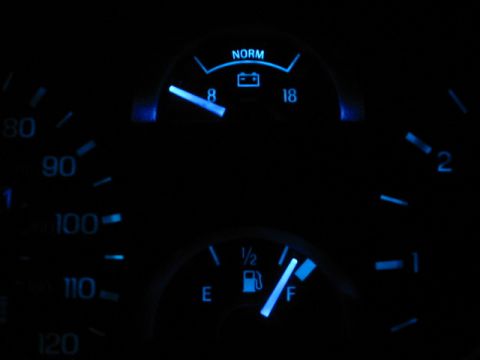 1995 Ford Thunderbird - The dashboard gauges, including fuel and battery indicators, glow blue in the dark.