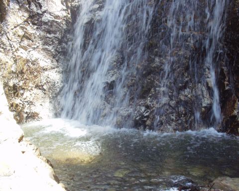 1997 Ford F-250 - A waterfall flows over a rocky cliff into a pool of water. The image has a watermark.