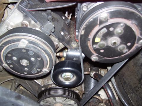 1992 Ford Bronco - Close-up of an engine's serpentine belt system, showing the tensioner and pulleys.