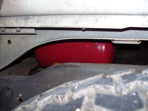1992 Ford Bronco - A close-up view of the undercarriage reveals a red component situated near the tire and frame.
