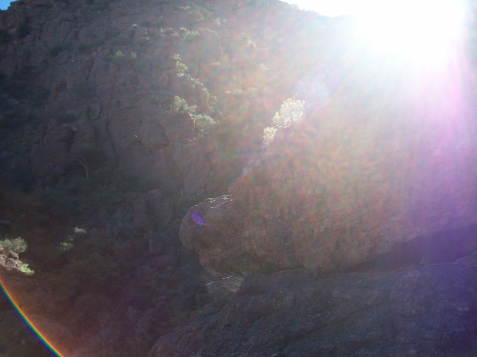 Rocky landscape with bright sun flare and rainbow lens effect