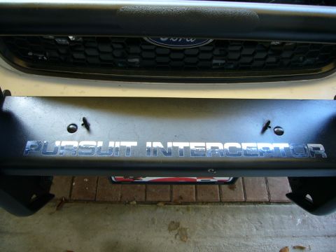 2000 Ford Crown Victoria - Close-up of a push bumper with 'PURSUIT INTERCEPTOR' lettering, above a Ford grille.