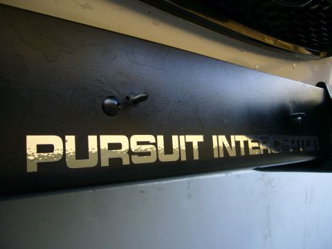 2000 Ford Crown Victoria - A close-up view of a black push bumper with "PURSUIT INTERCEPTOR" text in gold lettering.