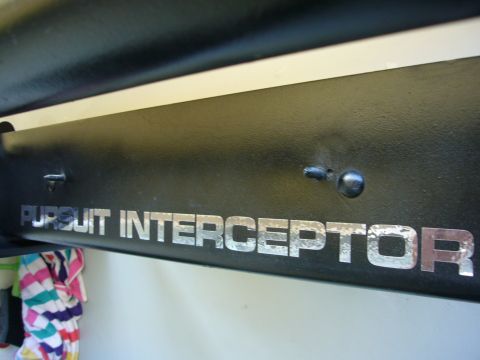 2000 Ford Crown Victoria - Close-up of a black push bumper decal with silver lettering that reads "PURSUIT INTERCEPTOR".
