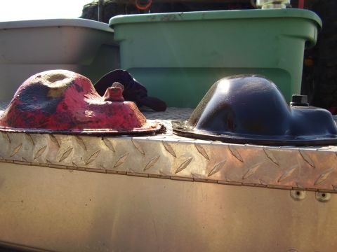 1981 Jeep CJ7 - Two oil pans, one red and one black, are displayed on a metal surface with diamond plate texture.