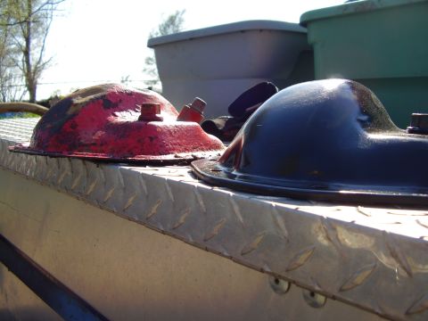 1981 Jeep CJ7 - Two automotive oil pans are shown on a diamond plate surface, with plastic containers in the background.