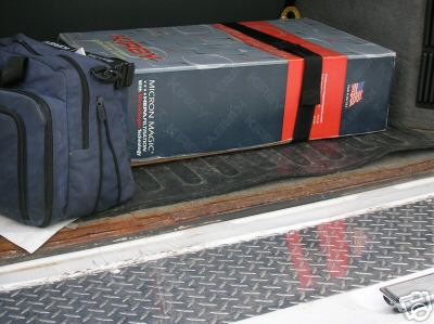 1995 Ford C-350 (Centurion Conversions) - A blue duffel bag and a large box secured with straps are visible in the bed of a truck.