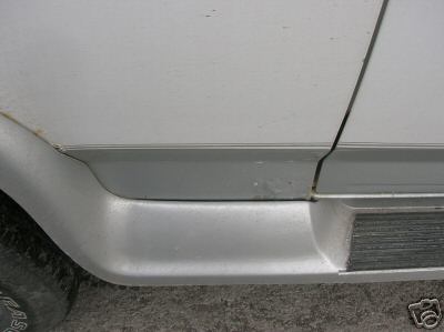 1995 Ford C-350 (Centurion Conversions) - A close view of the lower side panel and running board of a vehicle.