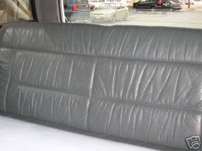 1995 Ford C-350 (Centurion Conversions) - Interior view of a gray leather rear seat with other vehicles visible through the window.