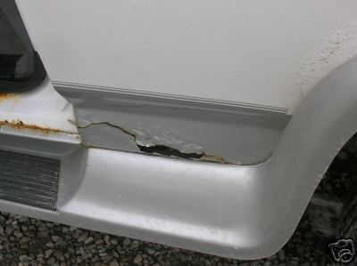 1995 Ford C-350 (Centurion Conversions) - Significant rust and damage are visible on the lower body panel of this vehicle.