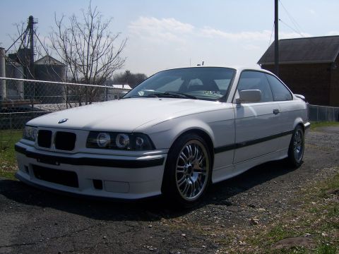 2001 BMW 3 Series - A white BMW coupe is parked on a gravel lot with a rural background.