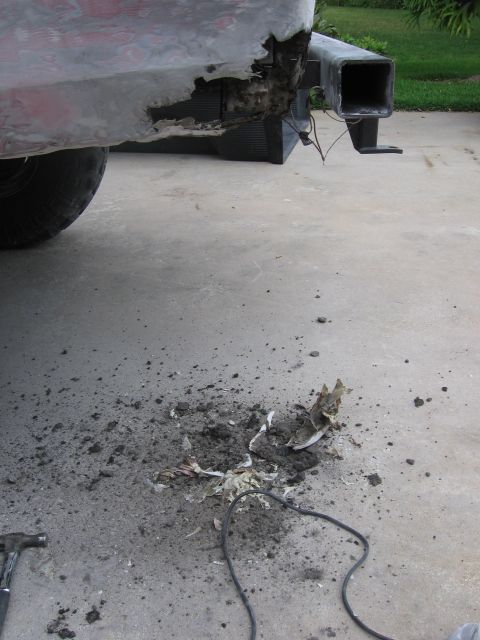 1974 Ford F-100 - The rear bumper and hitch of a truck show significant damage and rust.