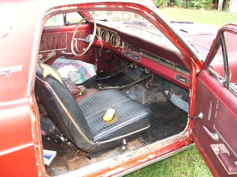 1966 Ford Ranchero - The interior of a 1966 Ford Ranchero, showing the dashboard, steering wheel, and seats, appears to be in a state of disrepair.