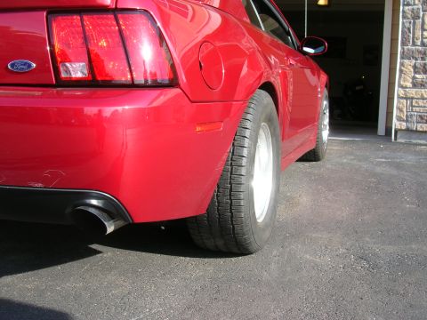 1979 Ford Bronco - Rear view of a red Ford Mustang, highlighting its taillight and wide tire.