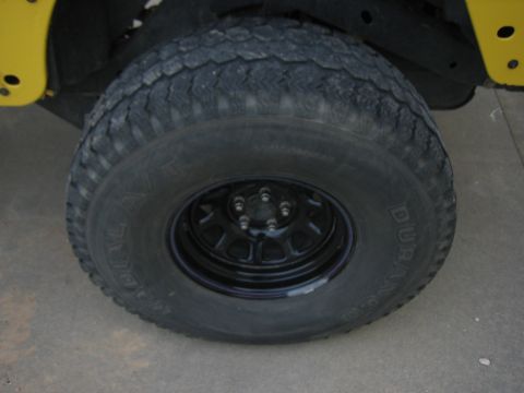 2001 Jeep Wrangler - Jeep Wrangler wheel and tire with yellow body panel detail.