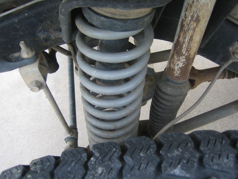 Front suspension coil spring and shock absorber, tire tread visible