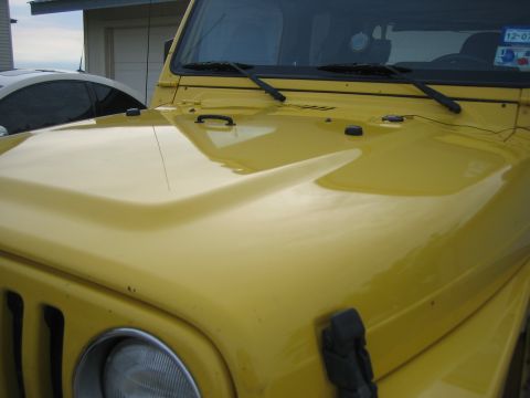 2001 Jeep Wrangler - Front view of a yellow 2001 Jeep Wrangler's hood, showing its distinctive shape.
