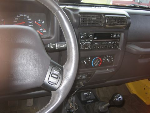 2001 Jeep Wrangler - Interior view of a Jeep Wrangler, showing the dashboard, steering wheel, and center console with gear shifter.