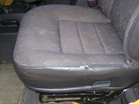 2001 Jeep Wrangler - The interior seat fabric has a repeating abstract pattern. The leather trim shows signs of wear and tear.