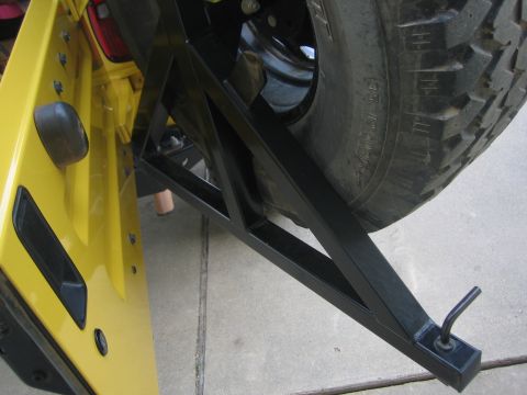 2001 Jeep Wrangler - Close-up view of a yellow Jeep door and the attached spare tire carrier system.