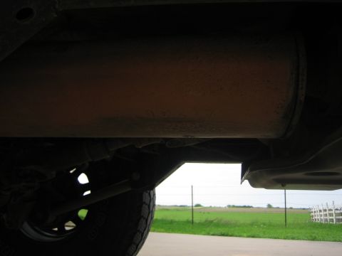 2001 Jeep Wrangler - Underside view of a vehicle's exhaust system and frame, with a field visible beyond.