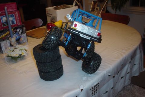 2000 Ford Crown Victoria - A remote-controlled car is positioned precariously on a pile of tires on a tablecloth.