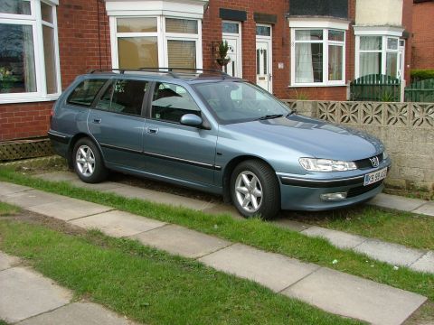 2001 Peugeot 406 - A blue 2001 Peugeot 406 station wagon is parked on a driveway in front of a residential building.