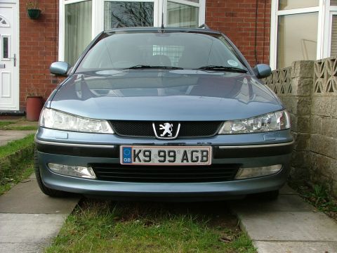 2001 Peugeot 406 - The front of a blue Peugeot 406 is shown parked in front of a brick house.