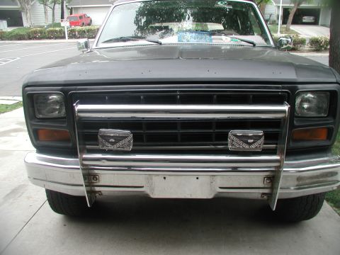 1981 Ford Bronco - Front view of a gray Ford Bronco with a chrome grille guard and custom lights.