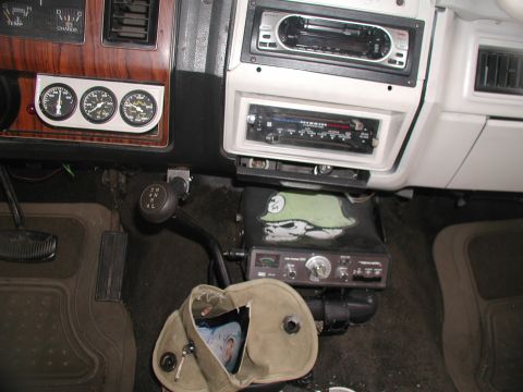 1981 Ford Bronco - The interior of a vehicle shows a dashboard with auxiliary gauges, a CB radio, and two car stereos.