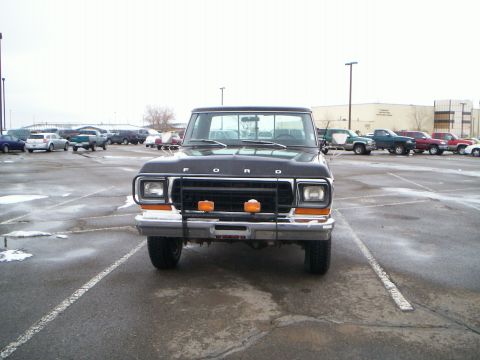 1979 Ford F-250 - A black Ford F-250 pickup truck is parked in a lot with other vehicles visible in the background.