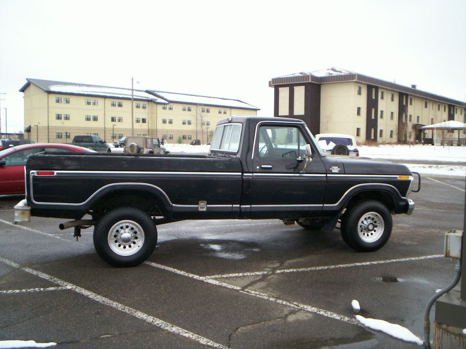 Black 1979 Ford F-250 pickup truck parked on asphalt with snow on the ground
