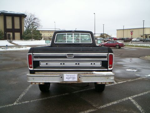 1979 Ford F-250 - Rear view of a black 1979 Ford F-250 pickup truck parked in a lot with snow on the ground.