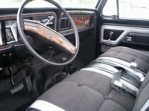 1979 Ford F-250 - The interior of a 1979 Ford F-250 features wood-grain trim on the dashboard and door panels.