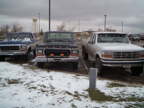 1979 Ford F-250 - Three Ford trucks, including a 1979 F-250, are parked in a snowy lot.
