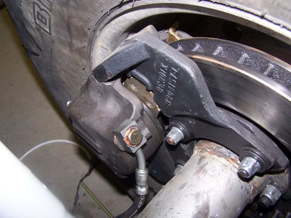Close-up of Bendix disc brake caliper and rotor with brake hose on a Bronco front axle, BFGoodrich tire behind