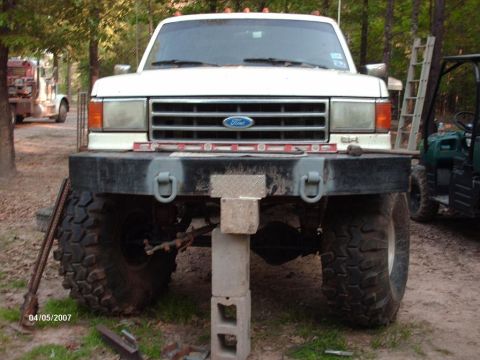 1990 Ford F-150 - This Ford truck, likely from the early 90s, is propped up on cinder blocks for work.