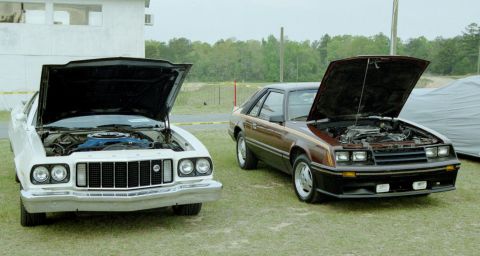 1976 Ford Ranchero - Two Ford vehicles, a 1970s Ranchero and an 1980s Mustang, are parked side-by-side with their hoods open.