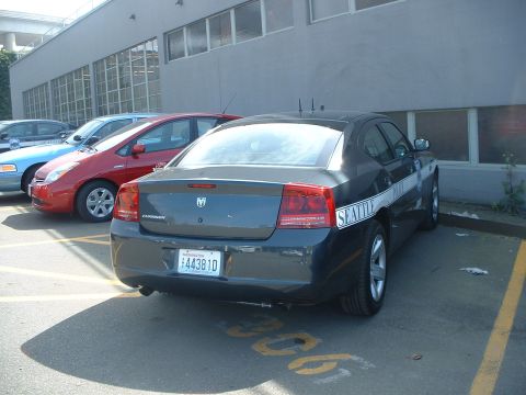 2000 Ford Crown Victoria - A Seattle Police Department Dodge Charger is parked in a lot with other vehicles.