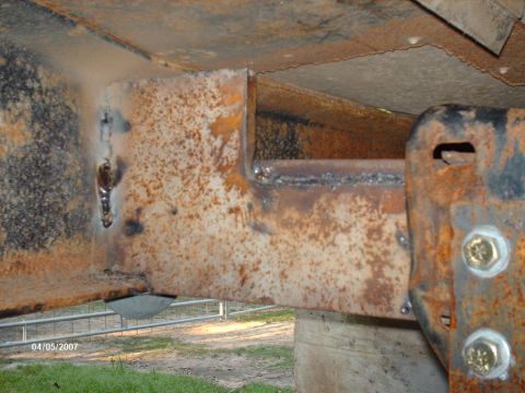 1990 Ford F-150 - This image shows a heavily rusted metal frame with fresh welds, indicating modifications to the vehicle's structure.